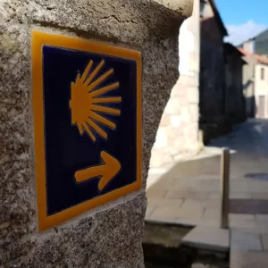 Wanderreise Portugiesischer Jakobsweg Küstenweg: Beschilderung des Weges mit Jakobsmuschel und gelbem Pfeil auf Kachel