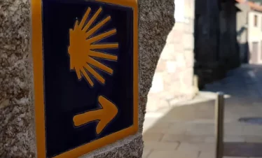 Wanderreise Portugiesischer Jakobsweg Küstenweg: Beschilderung des Weges mit Jakobsmuschel und gelbem Pfeil auf Kachel