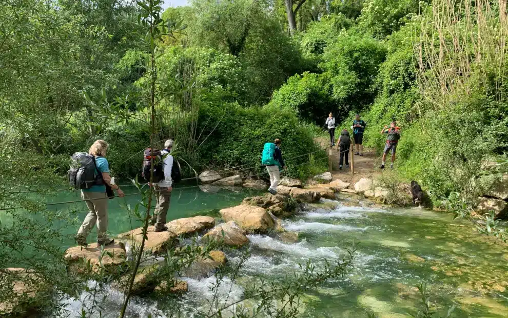 Wanderreise Höhepunkte der Via Francigena in der Toskana: Pilger bei der Überquerung des Flusses Elsa
