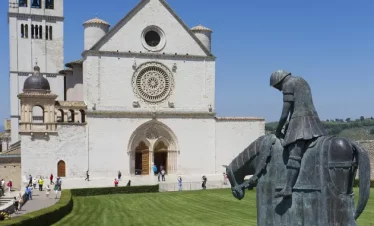 Wanderreise Franziskusweg: Basilika und Franziskus-Skulptur in Assisi
