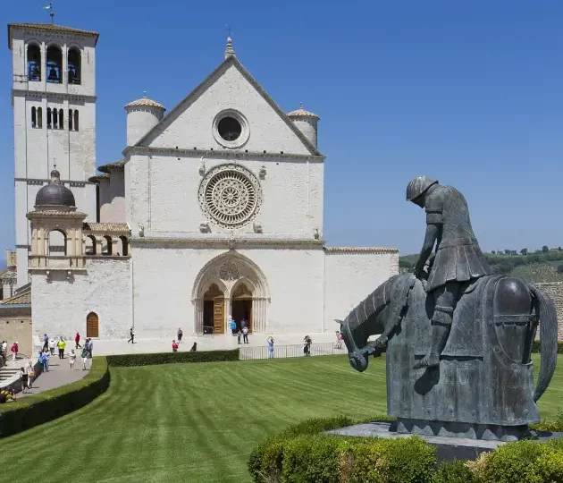 Wanderreise Franziskusweg: Basilika und Franziskus-Skulptur in Assisi